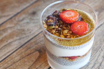 Healthy Chia Pudding with Granola and Strawberries served in a transparent glass