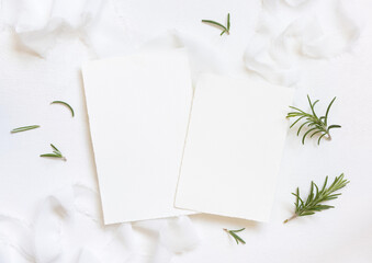 Blank cards near white silk ribbons and rosemary leaves top view, wedding mockup