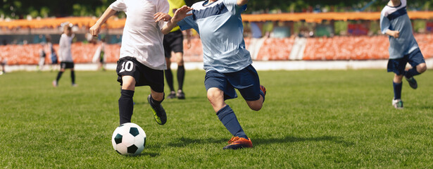 Two Kids Playing Football Ball on Grass Field. Happy School Boys Kicking Ball During Tournament...