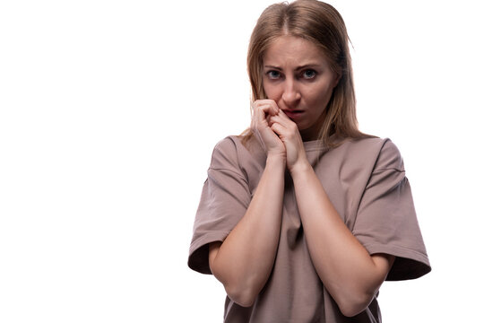 Fearful adult woman with blond hair on white background with copy space