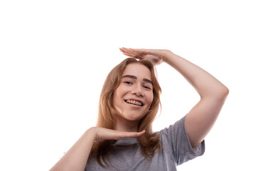 Fototapeta premium Smiling teenage girl with blond hair in a T-shirt on a white background