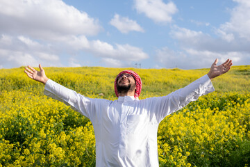 Arabian male enjoy healthy lifestyle in nature between yellow flowers in the field having fresh air...