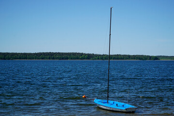 Blue yacht without sails at lake shore