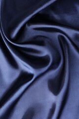 Crumpled dark blue silk fabric as background, top view