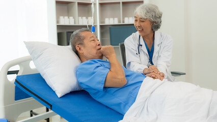 Fototapeta premium Senior Asian male patient visits the doctor for his annual checkup. Caregivers in caring for the elderly provide assistance on the bed Hospitals and Medicine and Health Care and Life Insurance