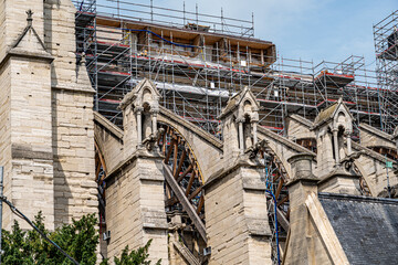 Horizontal image of the right side of the Notre Dame cathedral in Paris, on a sunny day in the middle of its reconstruction after the fire with a multitude of scaffolding installed for the works