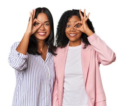 Young Latin businesswomen in studio showing okay sign over eyes