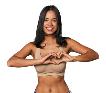 Young Filipino woman in light wear smiling and showing a heart shape with hands.