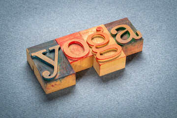 yoga word - text in letterpress wood type printing blocks stained by color inks on art paper