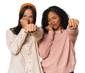 Young Latin friends together in studio throwing a punch, anger, fighting due to an argument, boxing.