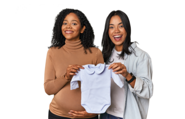 Two Latin women, one pregnant, with baby's bodysuit in studio