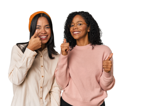 Young Latin friends together in studio raising both thumbs up, smiling and confident.