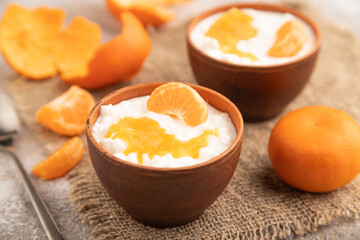 Grained cottage cheese with tangerine jam on brown concrete, side view, selective focus.