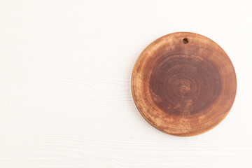 Empty round wooden cutting board on white wooden. Top view, copy space