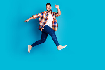 Full size photo of nice young man jump wear shirt isolated on blue color background
