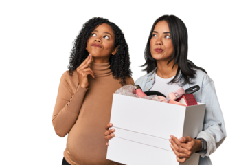 Latin women couple moving, one pregnant  looking sideways with doubtful and skeptical expression.
