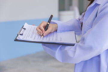 Doctor filling medical chart, checklist document, patient's information on clipboard. Doctor...