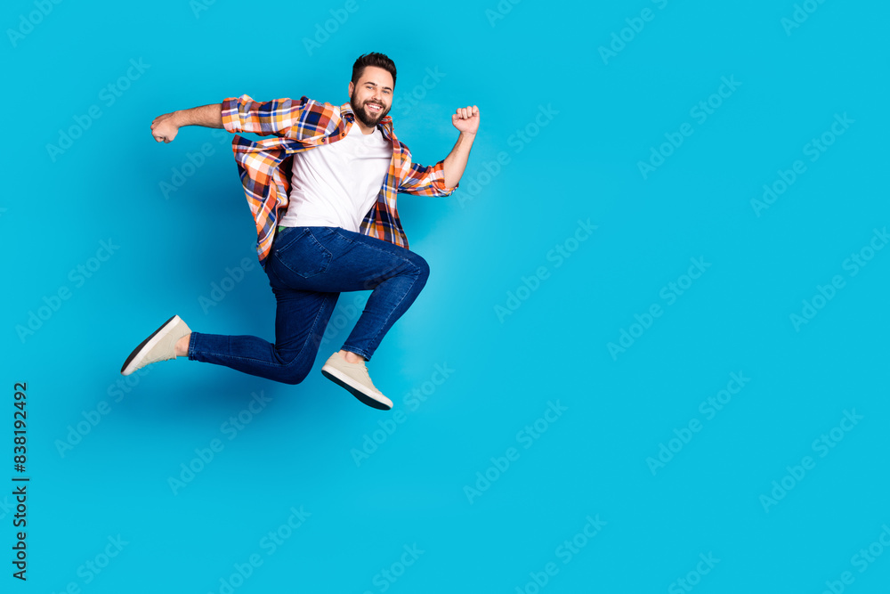 Sticker Full size photo of nice young man run empty space jump wear shirt isolated on blue color background