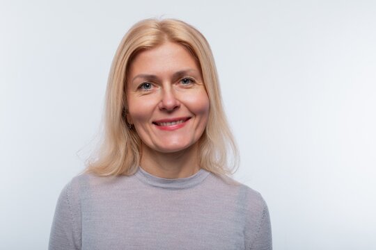 Charming 45 year old woman with blond hair wears light makeup