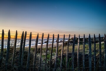 Obraz premium Fence in the dunes with sunset on the beach of Capbreton in France