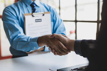 Employees shake hands after finishing a job interview.