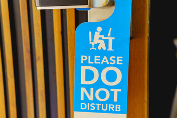 Please do not disturb sign hanging on the door handle  in hotel room.