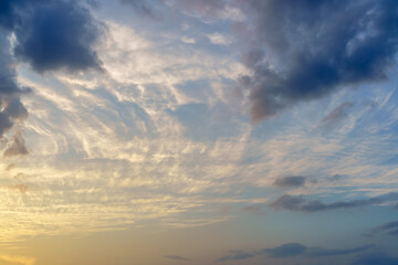 Obraz premium Colorful dramatic sky background with white and dark clouds in twilight hours.