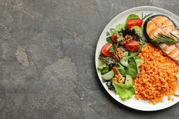 Plate with healthy food high in vegetable fats on grey textured table, top view. Space for text