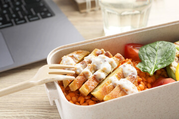 Healthy products high in vegetable fats near laptop on wooden table, closeup