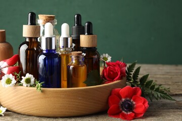 Aromatherapy. Different essential oils and flowers on wooden table