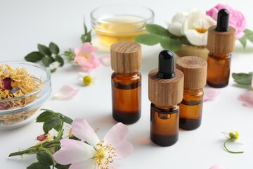 Aromatherapy. Essential oils and flowers on white table
