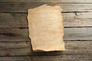 Sheet of old parchment paper on wooden table, top view