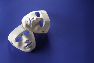 Theater arts. White masks on blue background, top view. Space for text