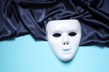 Theater arts. White mask and fabric on light blue background, top view