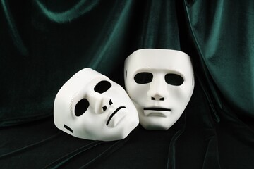 Theater arts. Two white masks on green fabric