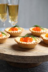 Delicious canapes with salmon and red caviar on table, closeup