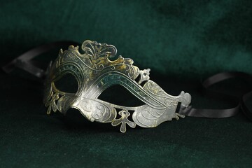 Theater arts. Venetian carnival mask on green fabric