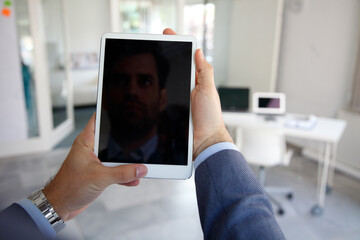Close-up of a businessman's hand holding touchpad at the office