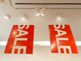 Red sale sign hanging from ceiling