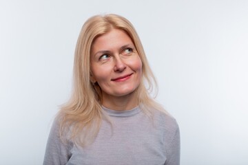 Obraz premium Middle-aged woman with blond hair and light makeup on a studio background