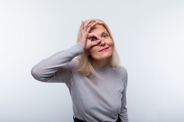 Cute mature blonde woman wearing a gray turtleneck confident in herself