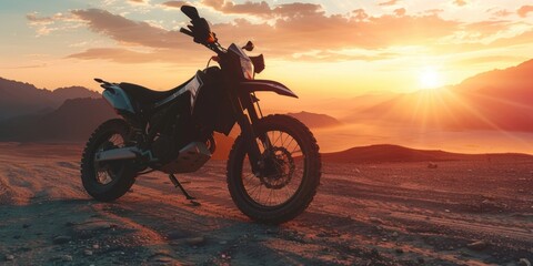 Obraz premium A motorcycle parked on a dirt road during sunset, perfect for outdoor or adventure themed images