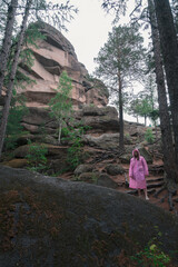 Woman in the taiga forest and rocks of the Stolby nature reserve park