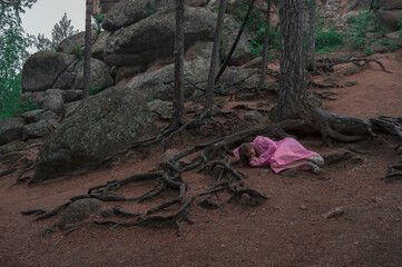 Woman in the taiga forest and rocks of the Stolby nature reserve park