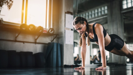 Cinematic tone of young attractive fitness woman exercise with machine in gym. Individual sport to...