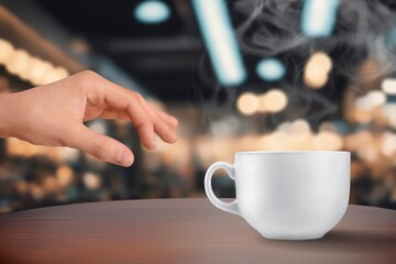 Woman hand and cup of coffee in room