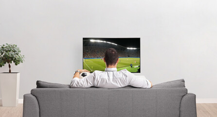 Rear view shot of a man watching a football match on tv