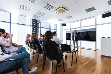 Multiracial group of entrepreneurs attending a seminar in multimedia classroom with smart board....