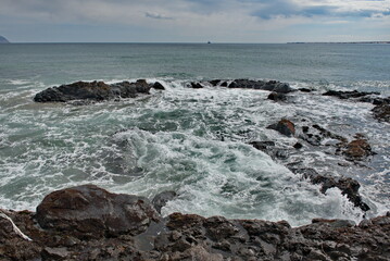 Russia. The Far East. The Kuril Islands. Waves of the Pacific Ocean beating against basalt rocks on...