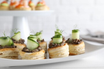 Delicious puff pastry with mushrooms, cucumber and dill on white table, closeup